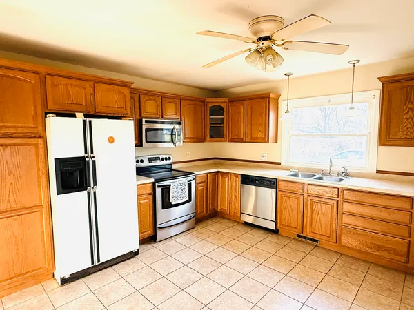 a kitchen with stainless steel appliances granite countertop a refrigerator a stove top oven a sink and dishwasher