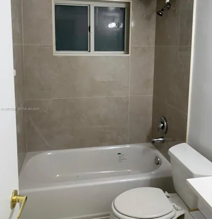 a white toilet and tub sitting next to a bathroom sink