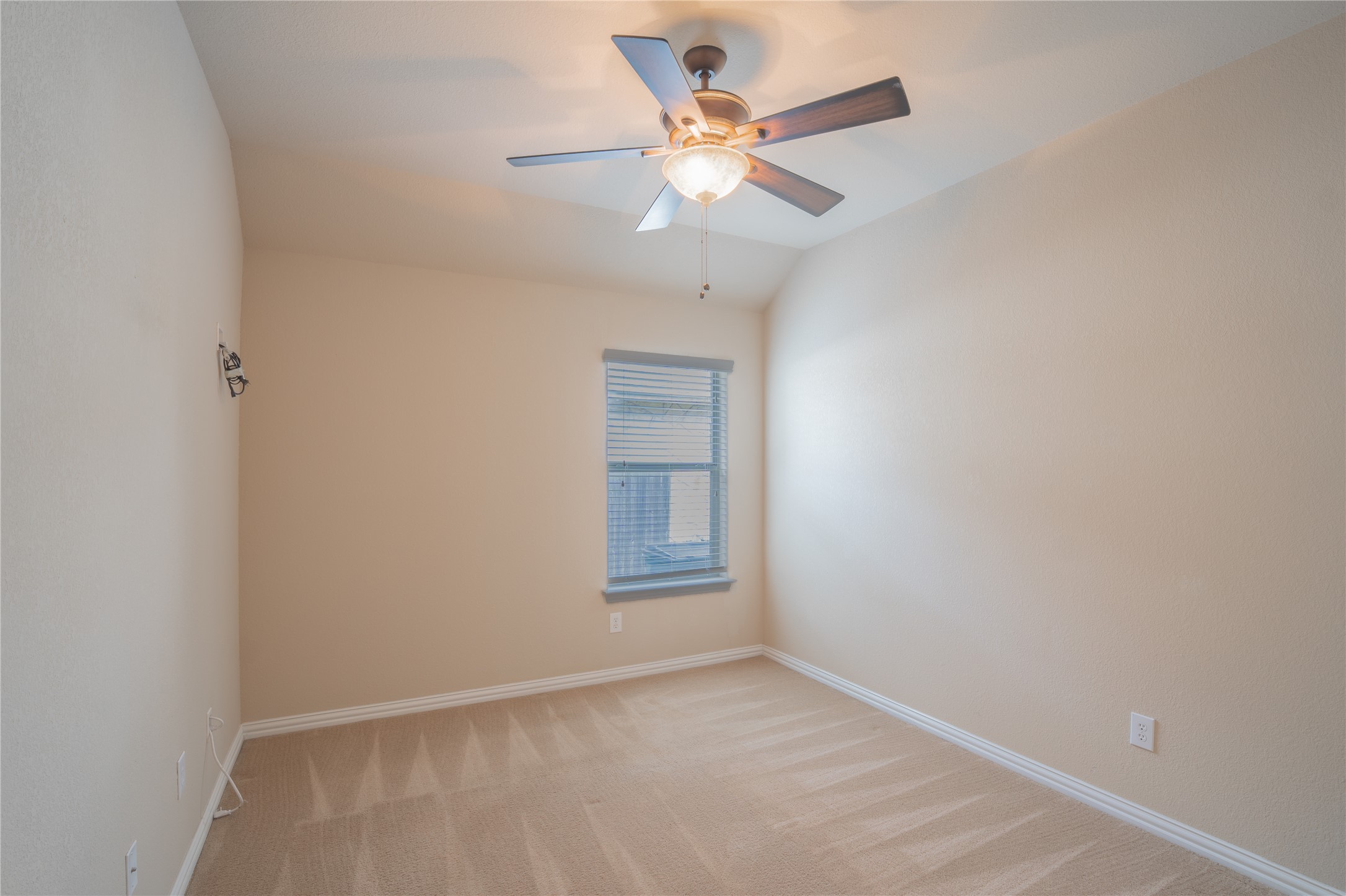 403 Tascate Street Georgetown, TX 78628 - Photo 17 of 26 A well-lit room with vaulted ceilings features plush carpet and a convenient ceiling fan for comfort.