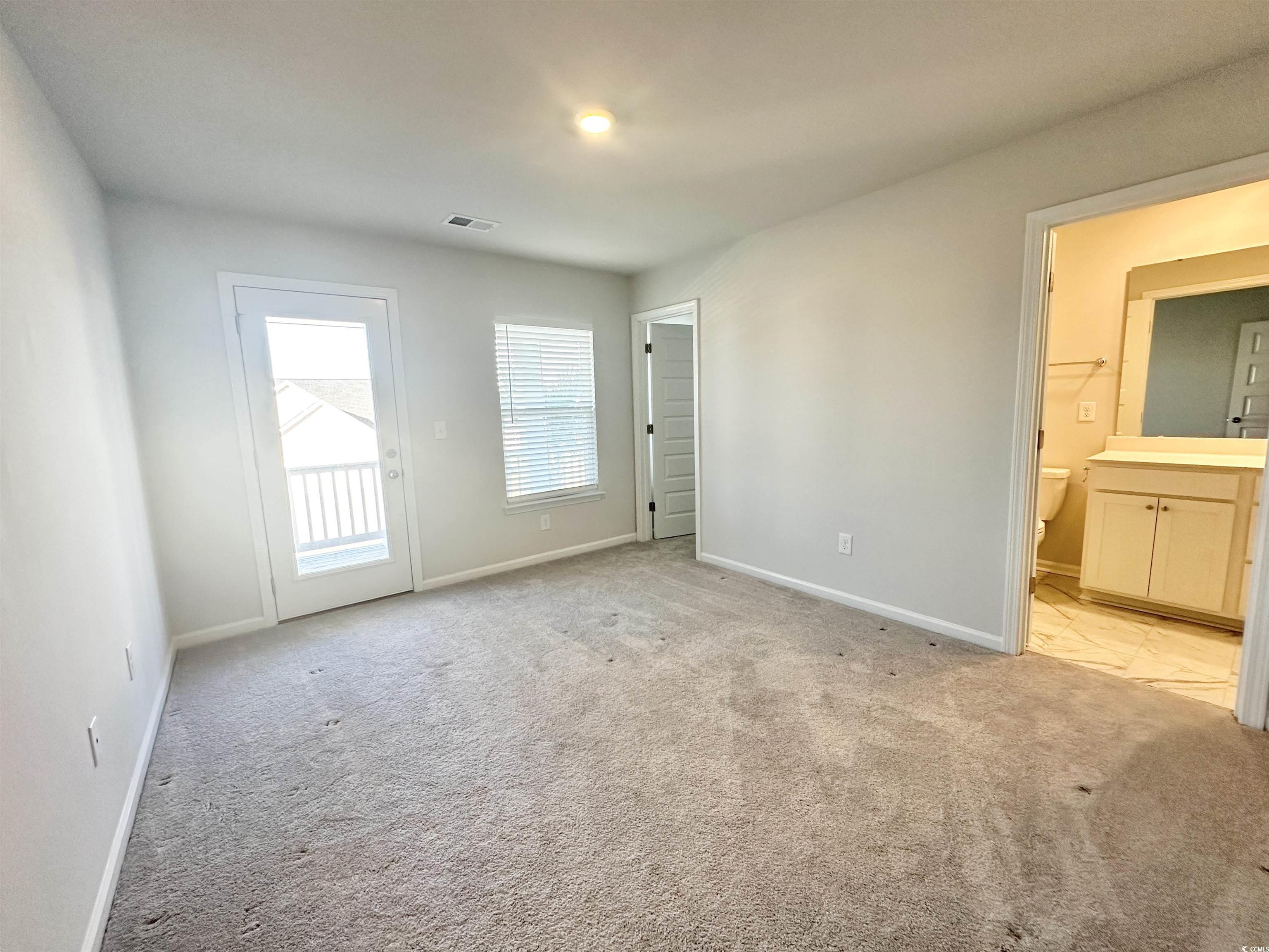 285 Augusta Grn Way Myrtle Beach, SC 29579 - Photo 16 of 28 Unfurnished bedroom featuring access to outside, light carpet, and ensuite bathroom