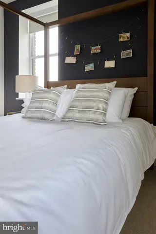 a bedroom with a large bed and a lamp with window