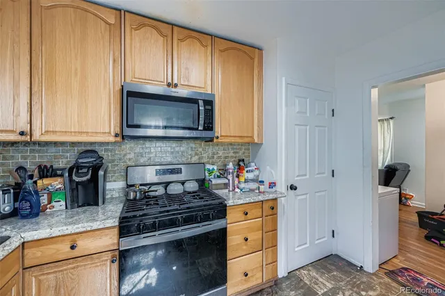 a kitchen with stainless steel appliances granite countertop a stove a sink and a microwave
