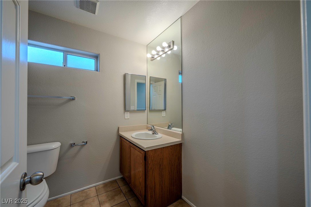 5283 Broadlake Lane Las Vegas, NV 89122 - Photo 14 of 36 Bathroom with vanity, light tile patterned flooring, and a textured wall