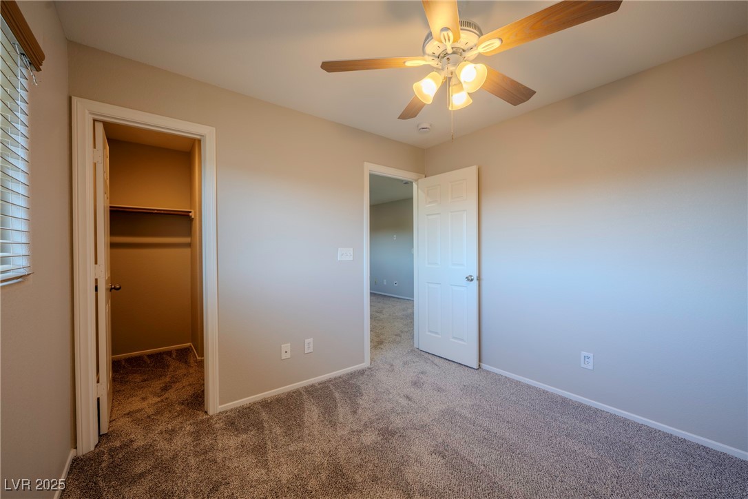 5283 Broadlake Lane Las Vegas, NV 89122 - Photo 17 of 36 Unfurnished bedroom with a walk in closet, a ceiling fan, and carpet flooring