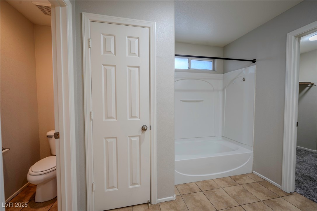 5283 Broadlake Lane Las Vegas, NV 89122 - Photo 9 of 36 Bathroom featuring light tile patterned floors, shower / tub combination, and a spacious closet