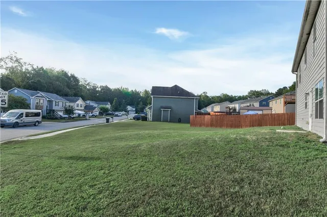 a view of a house with a big yard and large trees