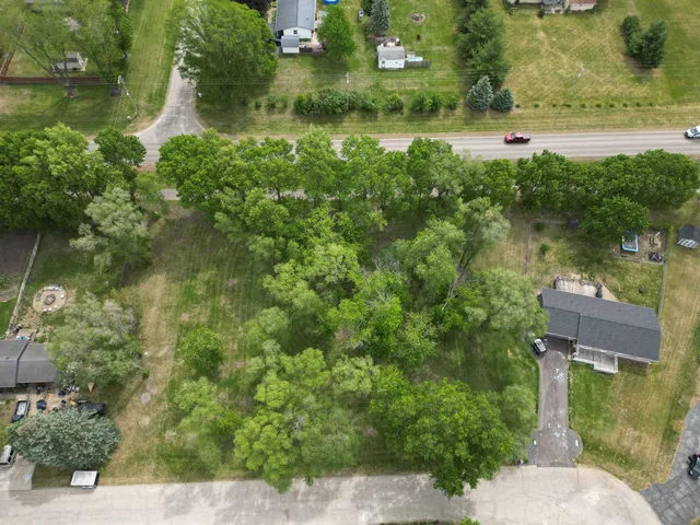 an aerial view of residential houses with outdoor space and trees
