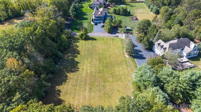 an aerial view of residential house with outdoor space and trees all around