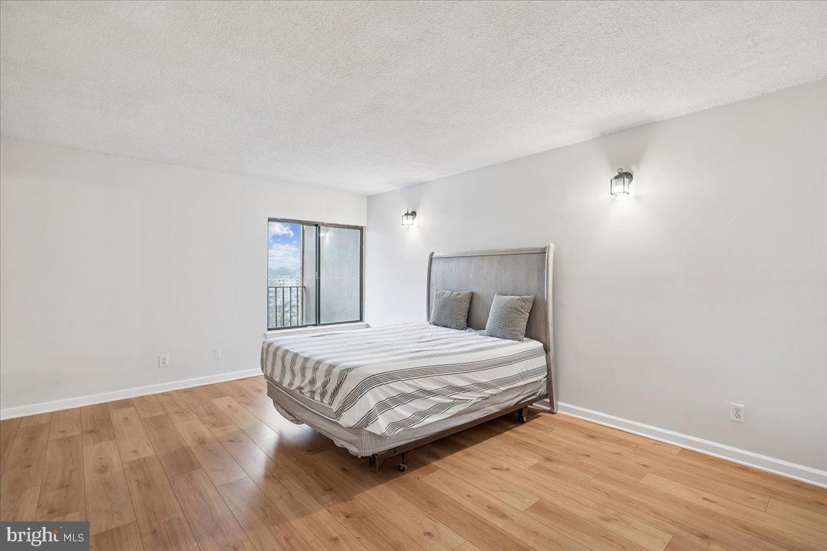 9200 Edwards Way, Unit 1202 Hyattsville, MD 20783 - Photo 13 of 34 a bedroom with a bed and wooden floor