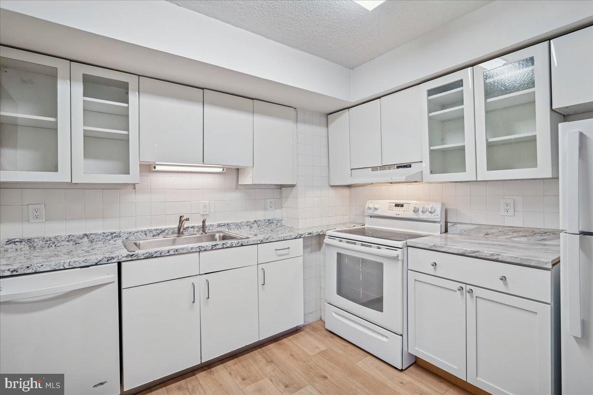 9200 Edwards Way, Unit 1202 Hyattsville, MD 20783 - Photo 4 of 34 a kitchen with stainless steel appliances granite countertop a sink and cabinets with wooden floor
