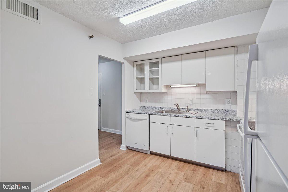 9200 Edwards Way, Unit 1202 Hyattsville, MD 20783 - Photo 5 of 34 a kitchen with granite countertop a sink and a stove top oven