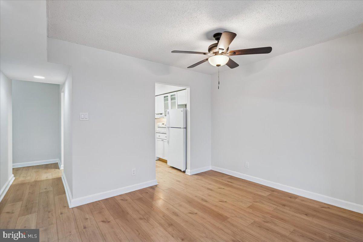 9200 Edwards Way, Unit 1202 Hyattsville, MD 20783 - Photo 6 of 34 an empty room with wooden floor cabinet and windows