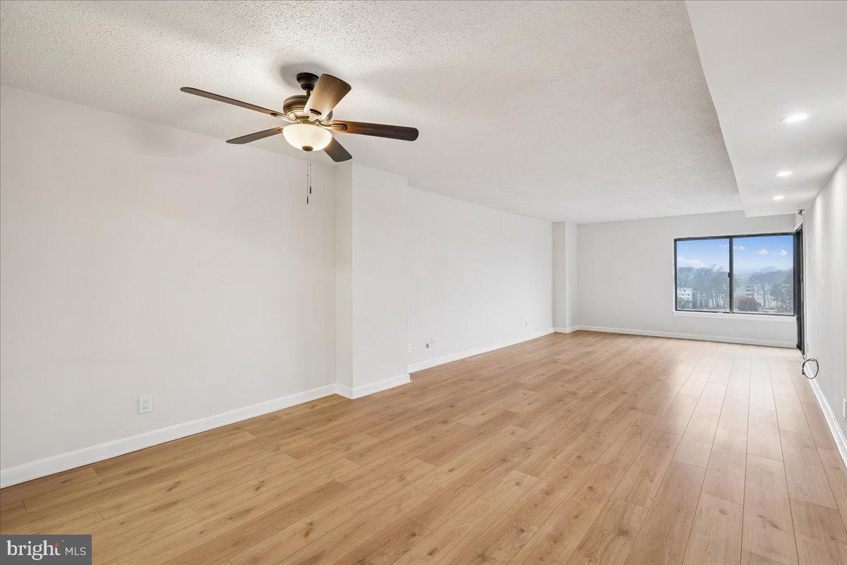 9200 Edwards Way, Unit 1202 Hyattsville, MD 20783 - Photo 7 of 34 a view of empty room with wooden floor and fan