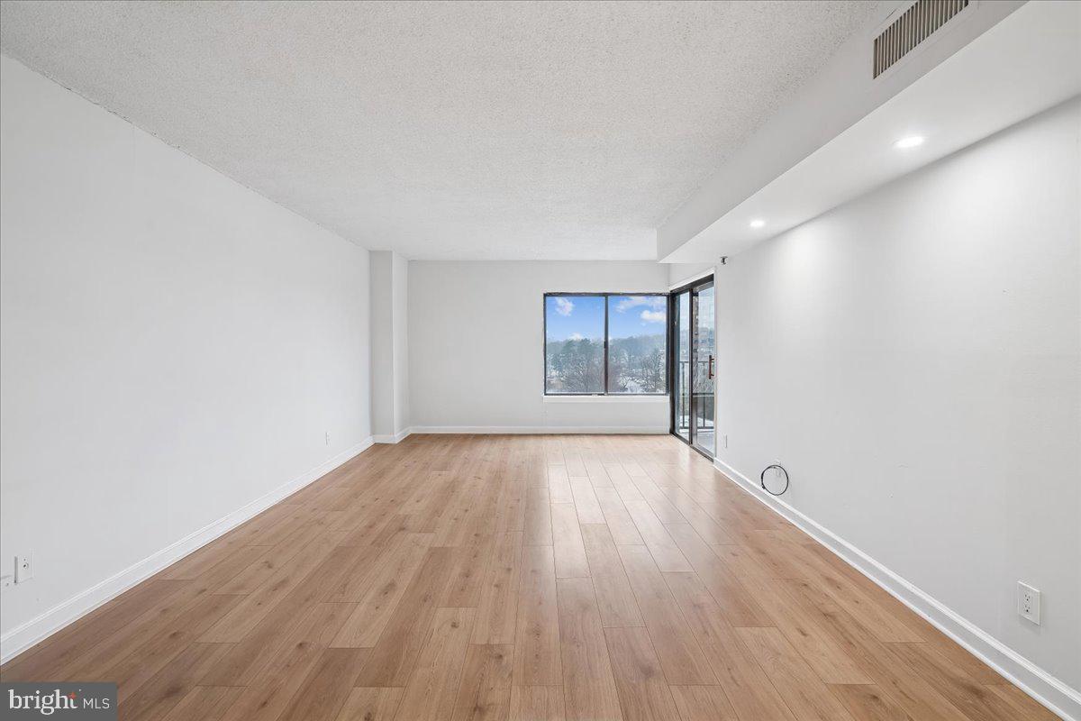 9200 Edwards Way, Unit 1202 Hyattsville, MD 20783 - Photo 8 of 34 an empty room with wooden floor and windows