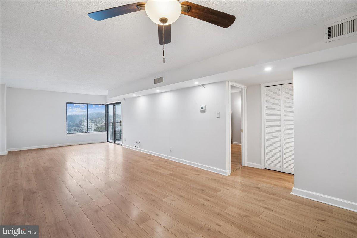 9200 Edwards Way, Unit 1202 Hyattsville, MD 20783 - Photo 9 of 34 a view of an empty room with wooden floor and a window