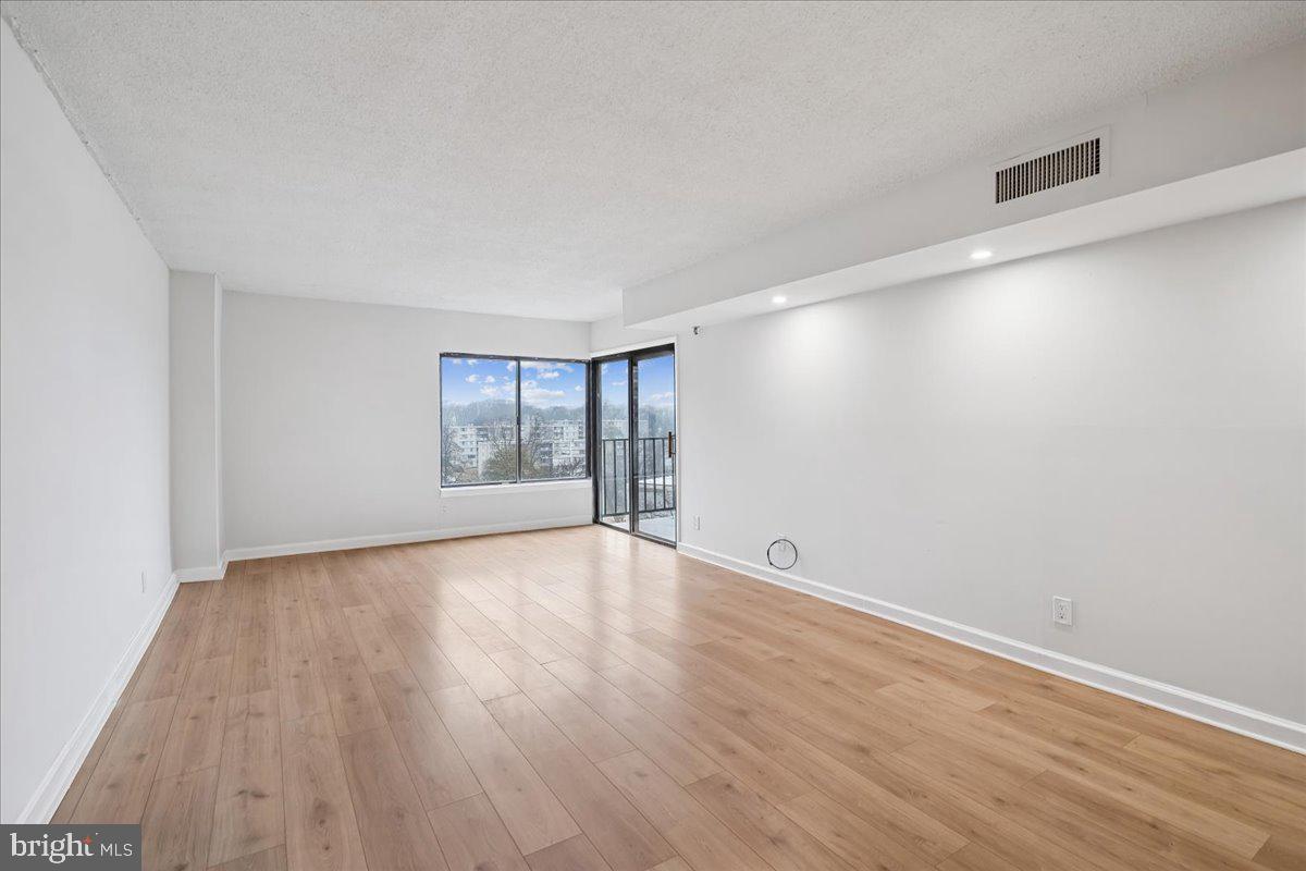9200 Edwards Way, Unit 1202 Hyattsville, MD 20783 - Photo 10 of 34 wooden floor in an empty room with a window