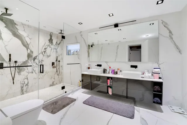 a spacious bedroom with a large bed and a flat tv screen