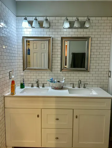 a bathroom with a sink double vanity and a mirror