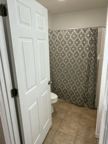 a bathroom with a toilet and a shower curtain