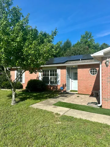 a view of a backyard with table and chairs and a large tree