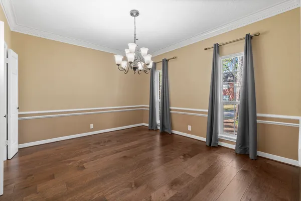 an empty room with wooden floor closet and windows