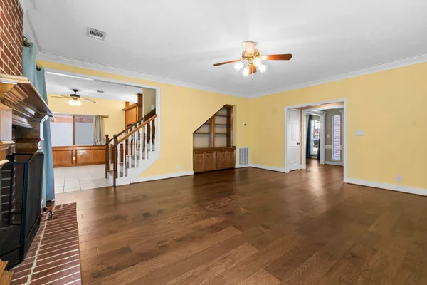 a view of a livingroom with wooden floor and staircase