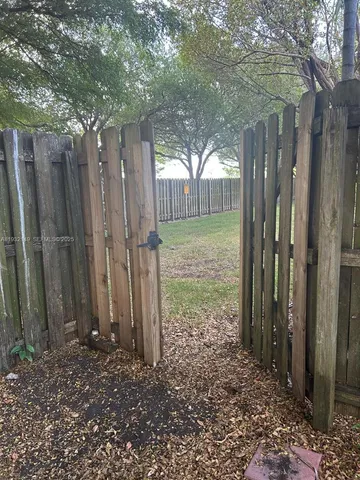 a view of backyard with tub and wooden fence