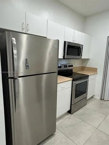 a kitchen with stainless steel appliances a refrigerator sink and microwave