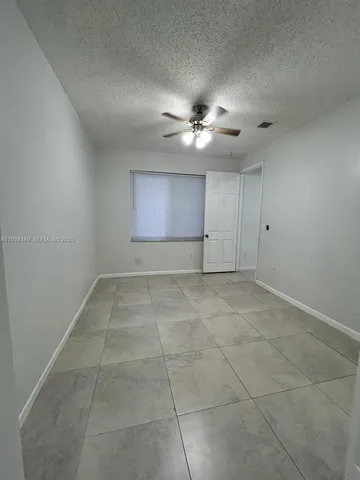 an empty room with chandelier fan
