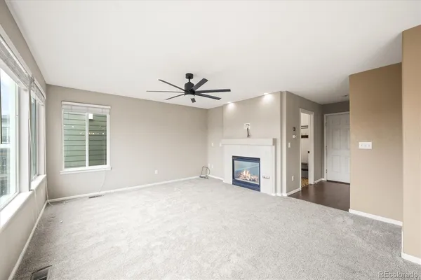 a view of an empty room with a fireplace and a window