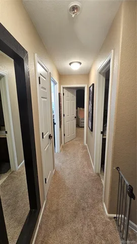 a view of hallway with furniture and a refrigerator