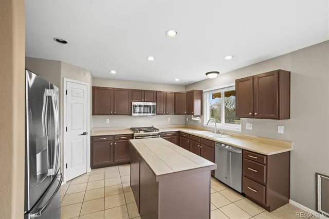 a kitchen with stainless steel appliances a refrigerator and a stove