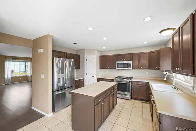 a kitchen with a sink stove top oven and refrigerator