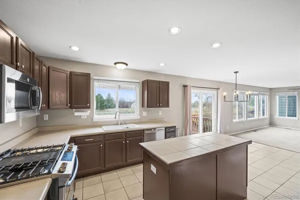a kitchen with a sink stove top oven and refrigerator