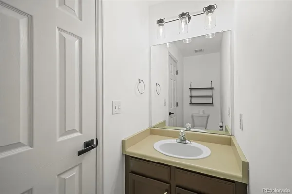 a bathroom with a granite countertop sink and a mirror