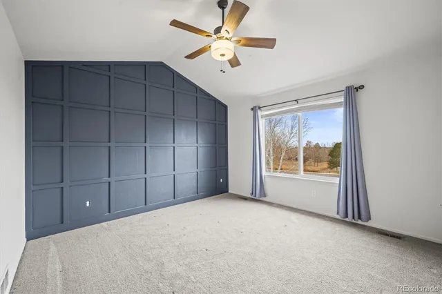 an empty room with closet and a chandelier fan