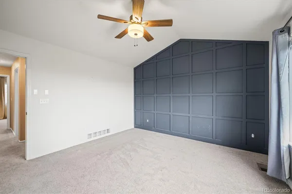 an empty room with closet and fan