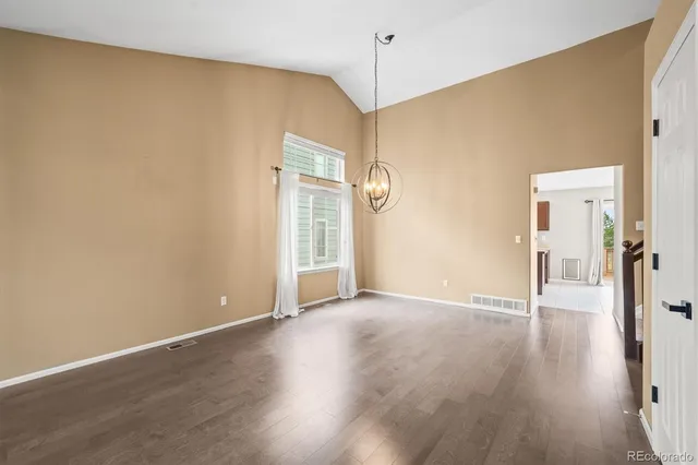 a view of a livingroom with wooden floor and a ceiling fan