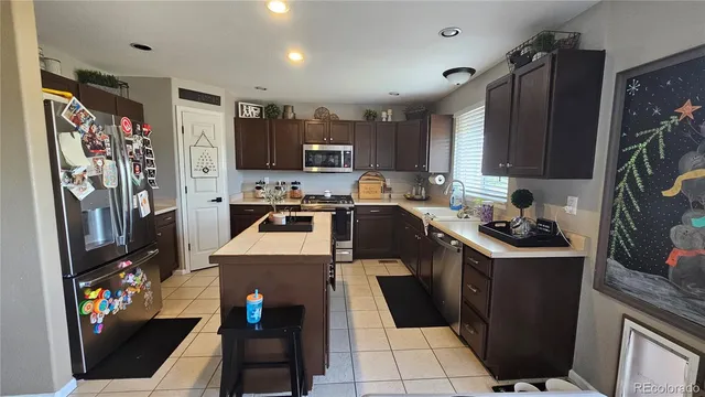 a kitchen with stainless steel appliances granite countertop a refrigerator stove and sink