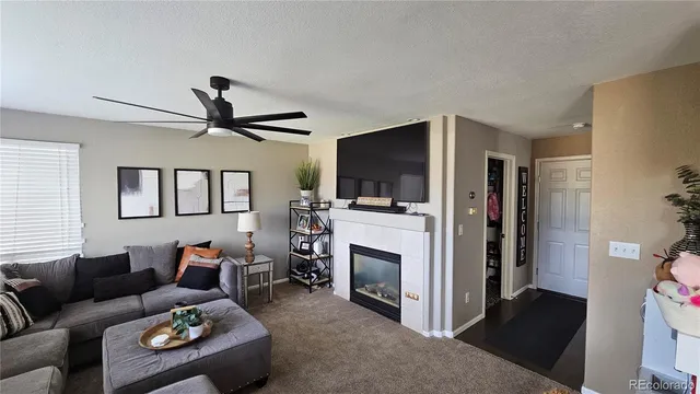 a living room with furniture a fireplace and a flat screen tv
