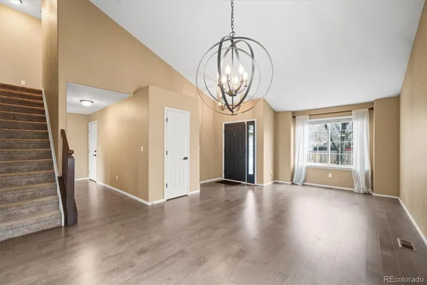 an empty room with wooden floor and mirror
