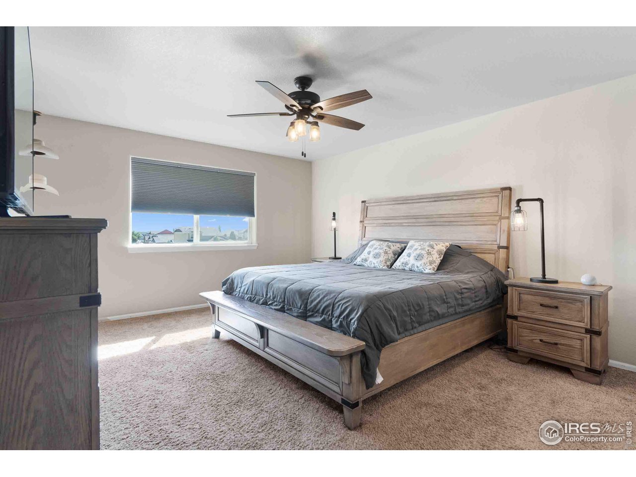522 Lowland Street Severance, CO 80550 - Photo 14 of 30 a spacious bedroom with a bed and a flat tv screen on the dresser