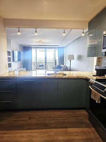 a kitchen with stainless steel appliances granite countertop a refrigerator a stove and a sink