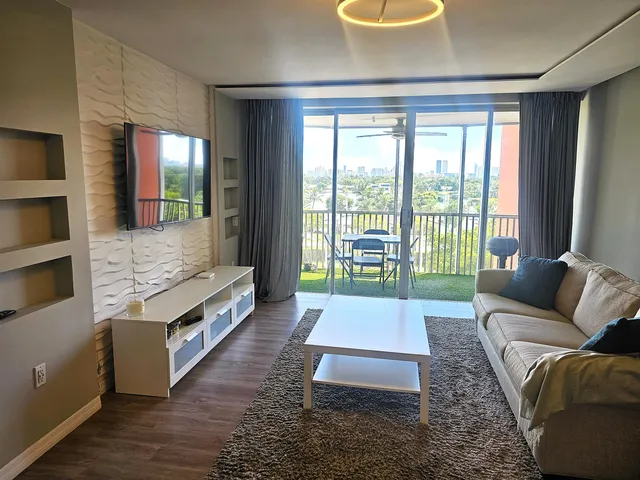 a living room with furniture and a floor to ceiling window