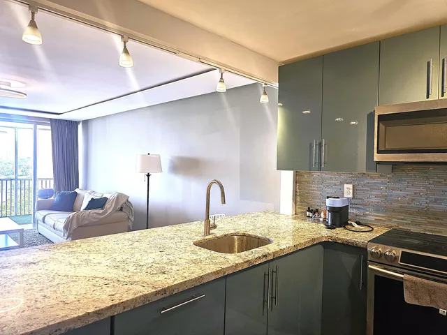 a kitchen with stainless steel appliances granite countertop a sink window and cabinets
