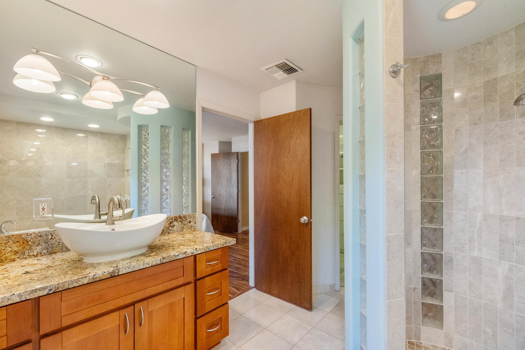 150 Puukolii Road, Unit 18 Lahaina, HI 96761 - Photo 30 of 49 a bathroom with a granite countertop sink and a mirror