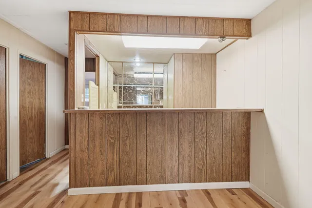 a view of a hallway with wooden floor and staircase
