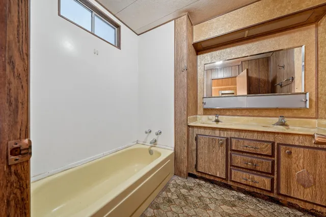 a bathroom with a tub sink and mirror