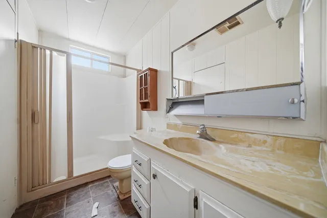 a spacious bathroom with a granite countertop sink a toilet and shower