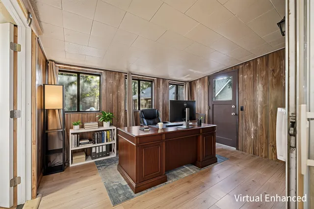 a view of a room with kitchen island stainless steel appliances wooden floor and windows